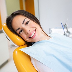 Woman with dental implants in Reynoldsburg, OH leaning in dental chair and smiling