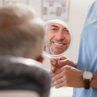 man smiling in circle mirror