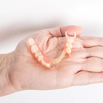 partial denture in hand