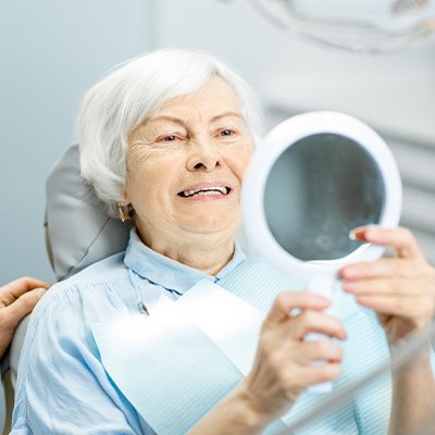 elderly woman smiling in circle mirror