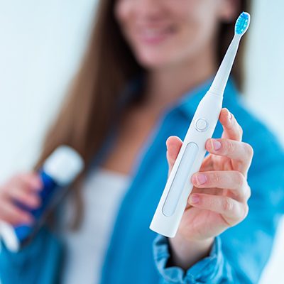 woman holding electric toothbrush