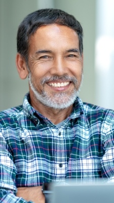 man in blue plaid shirt smiling