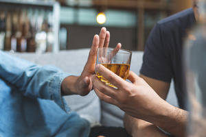 Hand being used to stop a glass of alcohol