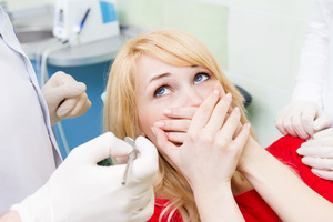 Female patient covering her mouth at dentist’s office